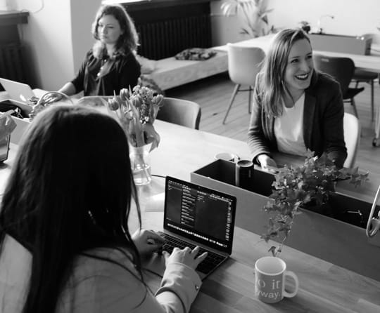 Image of three people working on a office
